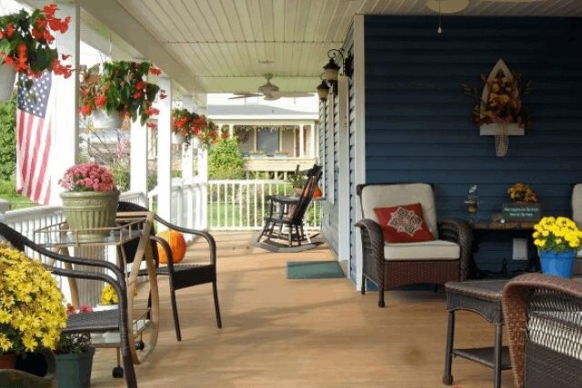 A porch with chairs and tables on it