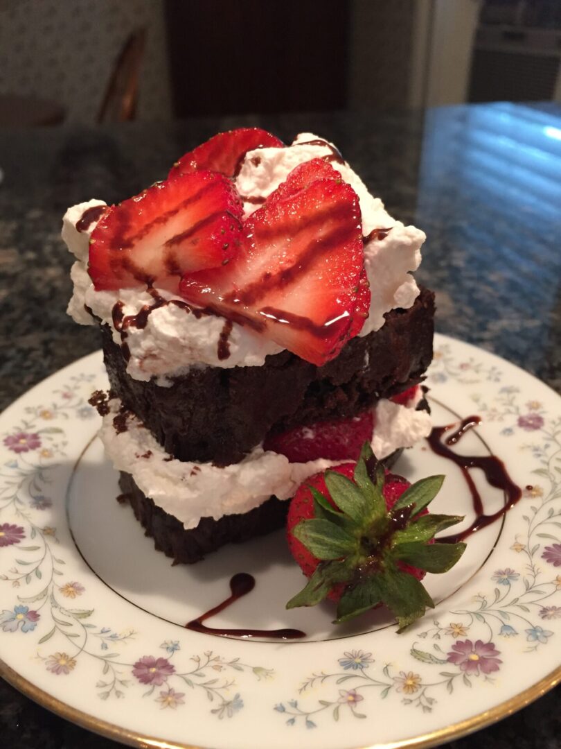 A piece of cake with whipped cream and strawberries on top.