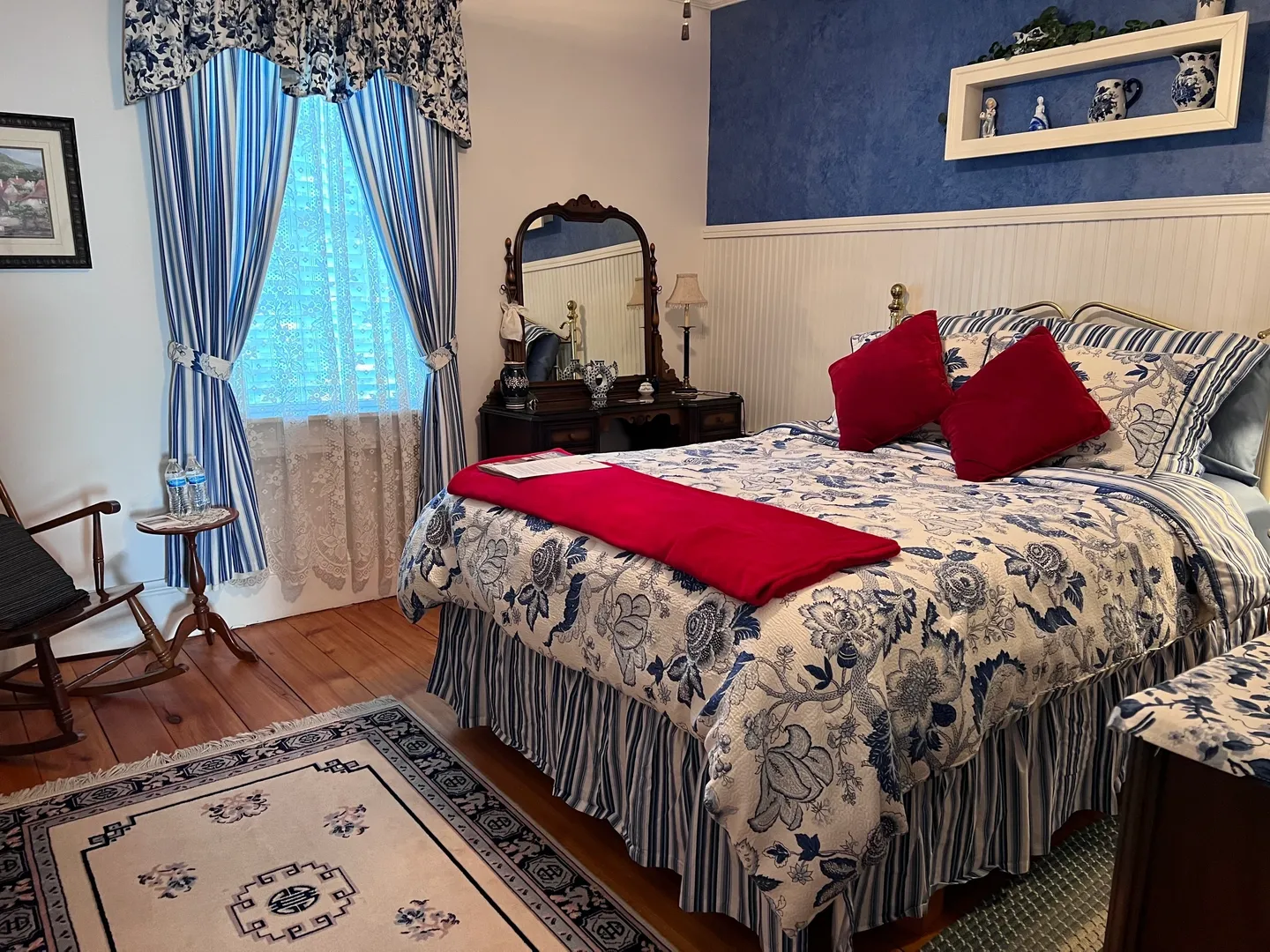A bedroom with blue walls and red pillows.
