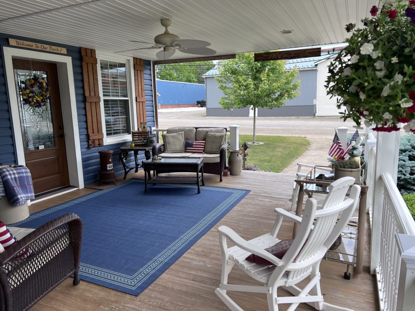 A porch with rocking chairs and a rug.