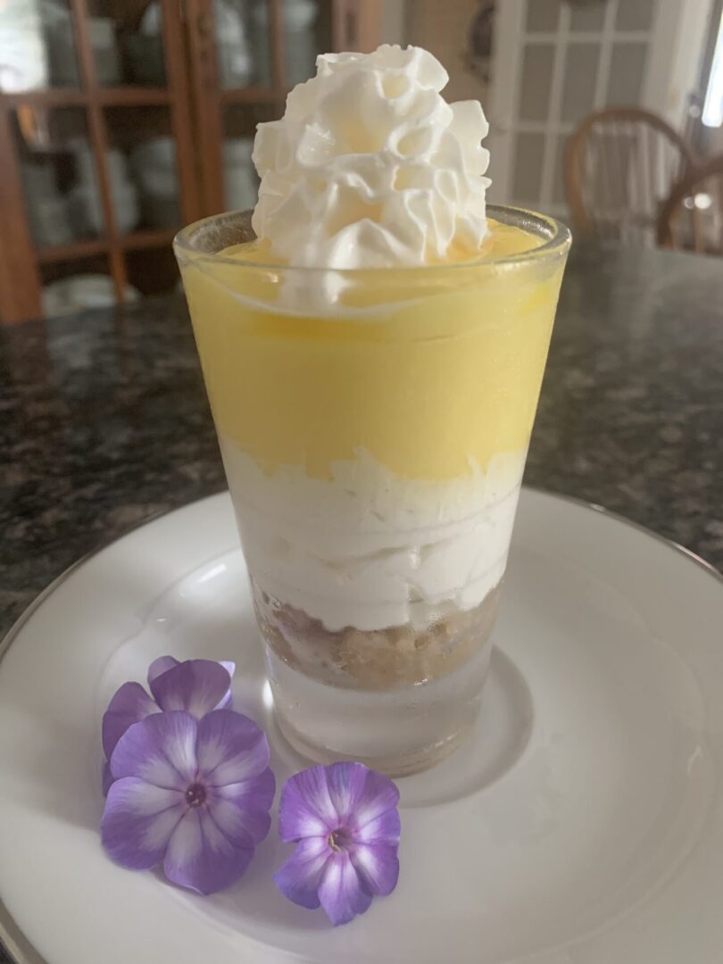 A small glass of ice cream with whipped topping.
