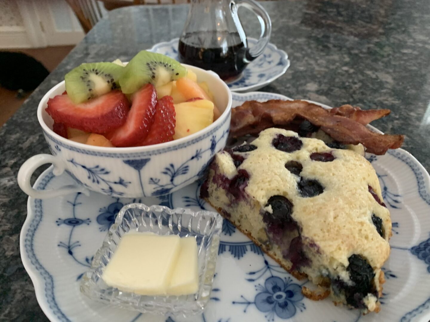 A plate of food with fruit and a slice of cake.