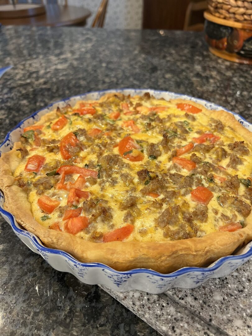 A quiche with meat and vegetables in it.