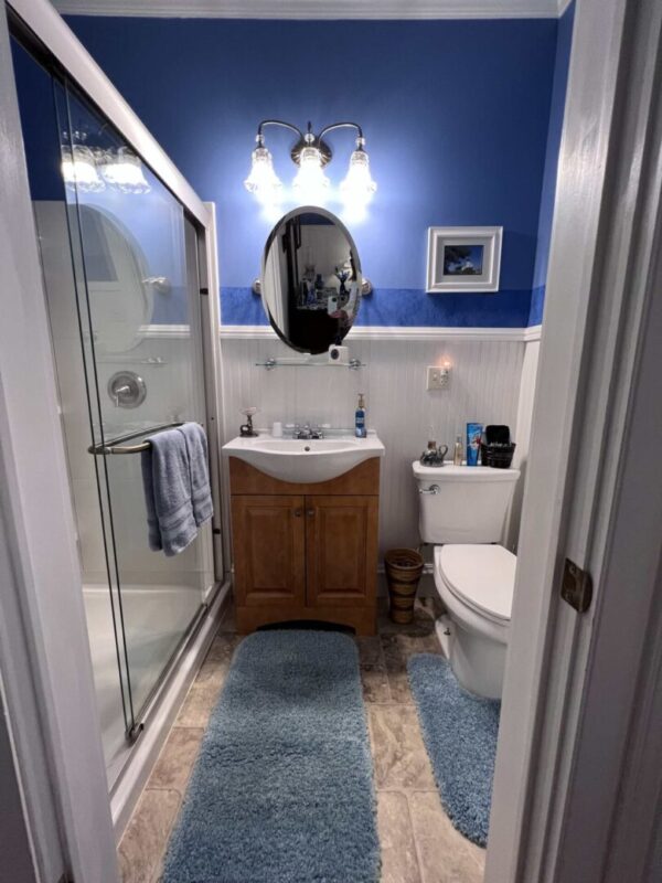 A bathroom with blue walls and white tile floors.